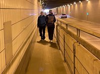 Bild zeigt den Flughafentunnel mit zwei sich entgegenkommenden Fußgängern