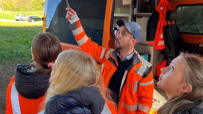 Kinder stehen vor einem Einsatzfahrzeug der Brückenprüfung
