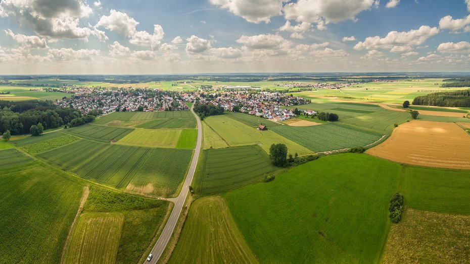 Ländlicher Raum Bild zeigt Landwirtschaft mit Ort im Hintergrund