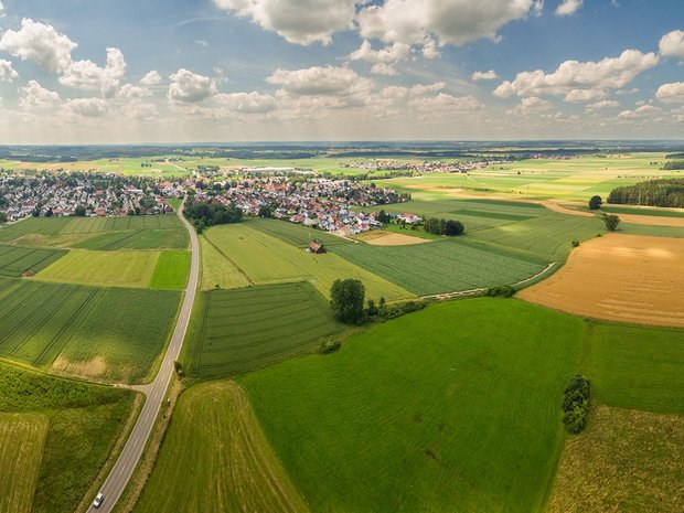 Ländlicher Raum Bild zeigt Landwirtschaft mit Ort im Hintergrund