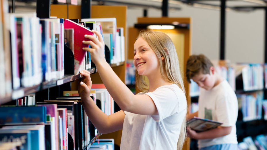 Kinder suchen Bücher in einer Bibliothek Kinder suchen Bücher in einer Bibliothek