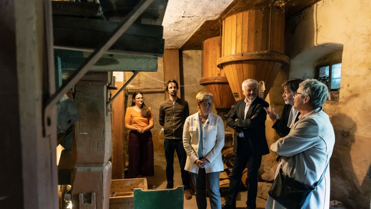 Die Bauherren Miriam Lüer und Adrian Groß, Ministerin Nicole Razavi MdL, Regierungspräsident Wolfgang Reimer und der Präsident des LAD Prof. Dr. Claus Wolf und Prof. Dr. Ulrike Plate vom LAD (v.l.n.r.) in der Oberen Mühle am Amorsbach bei Külsheim