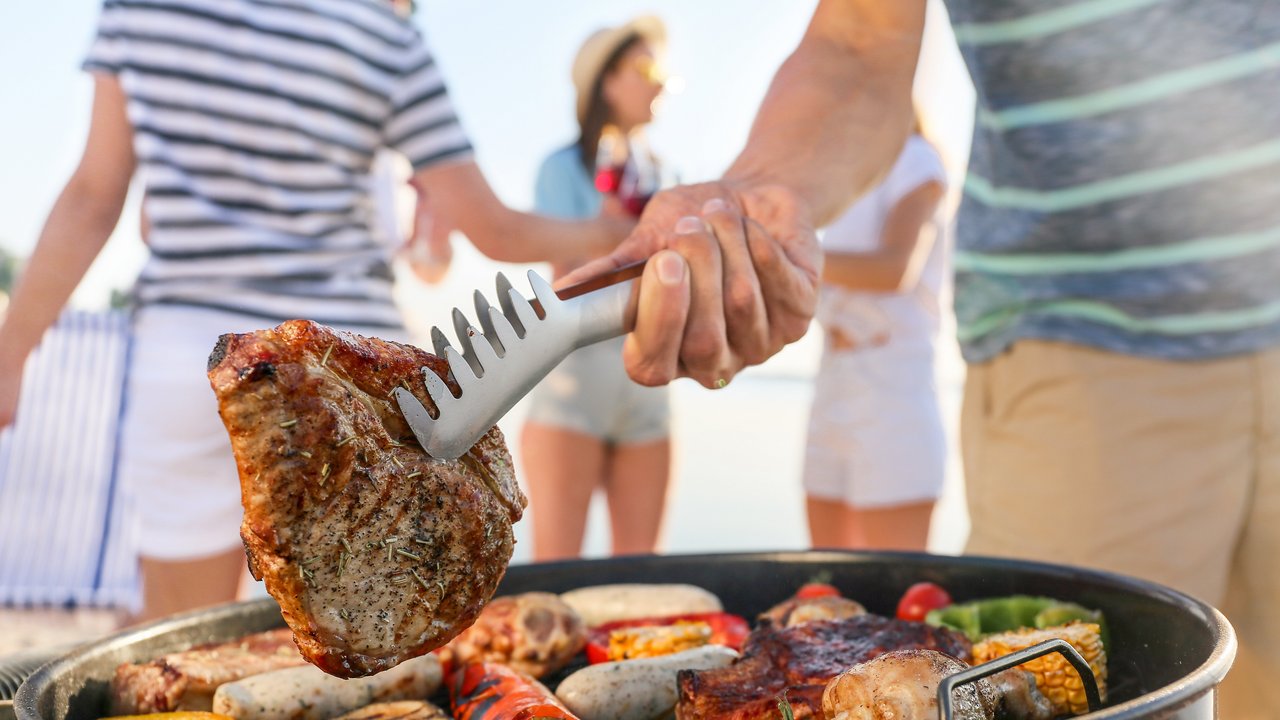 Bild zeigt einen Grill mit Fleisch und Gemüde