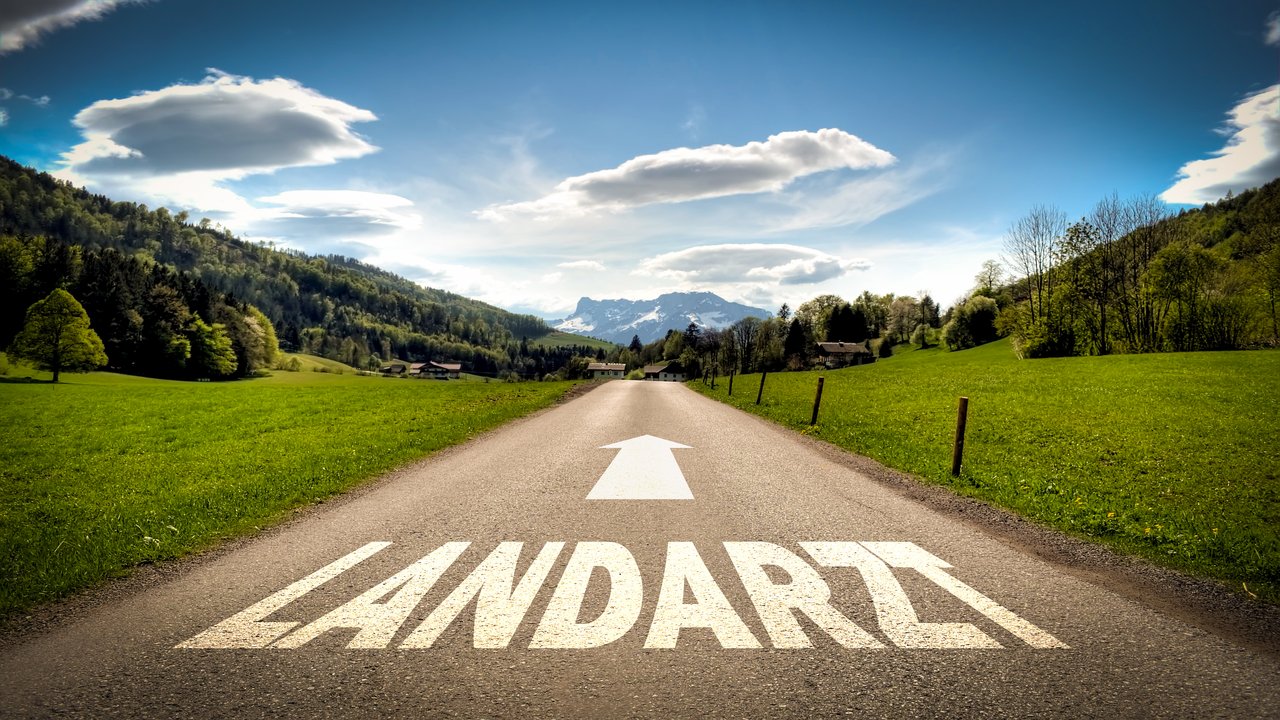 Straße auf dem Land mit Schriftzug Landarzt