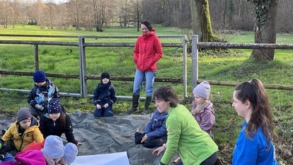 Regierungspräsidentin Bay sieht Kindern beim Spielen in der Natur zu