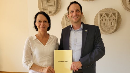Regierungspräsidentin Susanne Bay übergibt Dr. Sebastian Kampe, Bürgermeister der Gemeinde Rot am See, den Förderbescheid in Höhe von rund rund 5,8 Millionen Euro