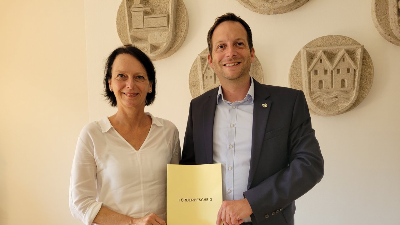 Regierungspräsidentin Susanne Bay übergibt Dr. Sebastian Kampe, Bürgermeister der Gemeinde Rot am See, den Förderbescheid in Höhe von rund rund 5,8 Millionen Euro