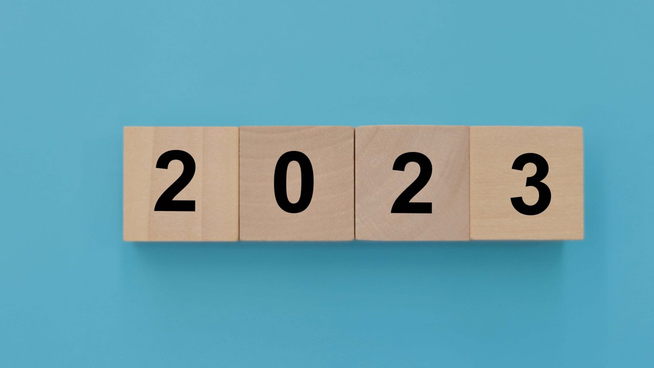 Holzwürfel auf hellblauem Hintergrund die die Zahl 2023 bilden